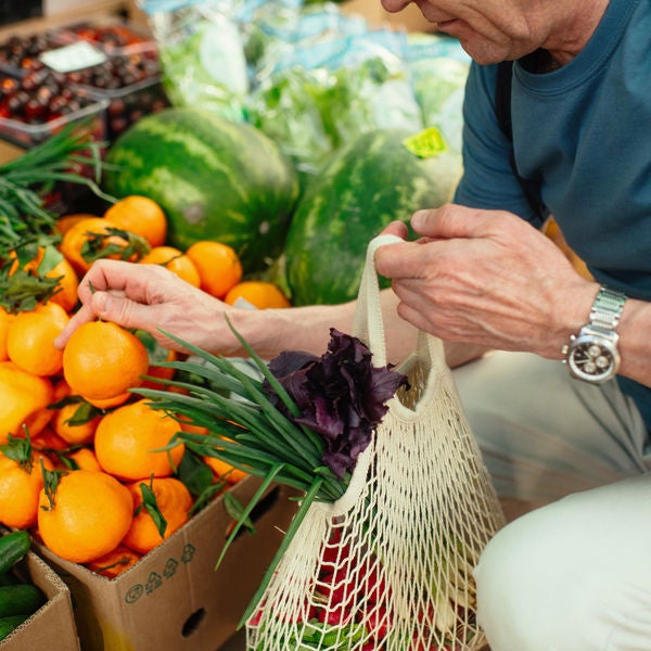 Senior man choosing tangerines at a farmer's market