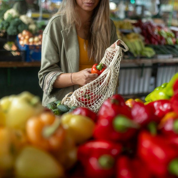 A woman who eats healthily chooses fresh organic vegetables at the street market