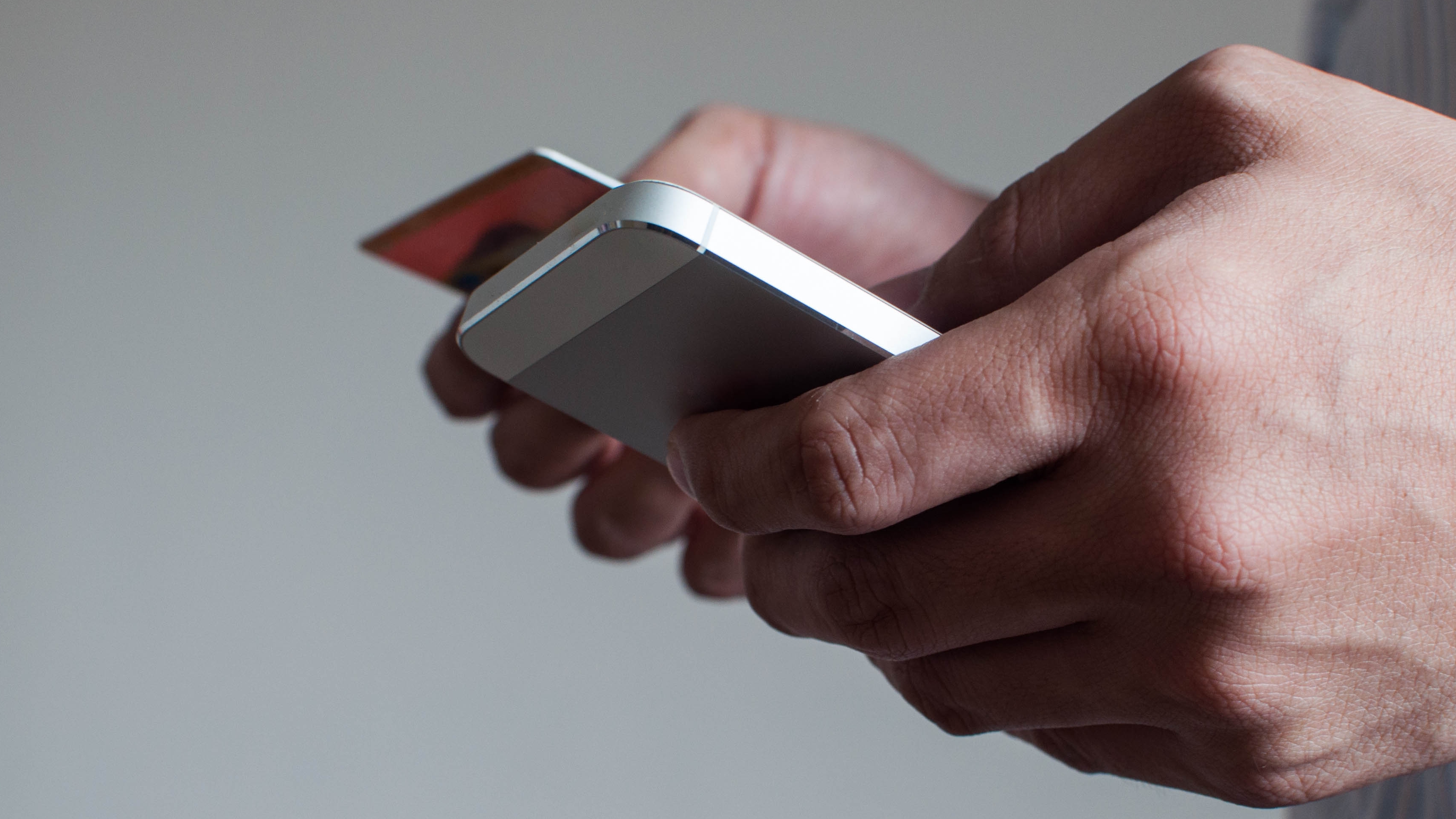A businessman is buying online using his mobile phone and credit card